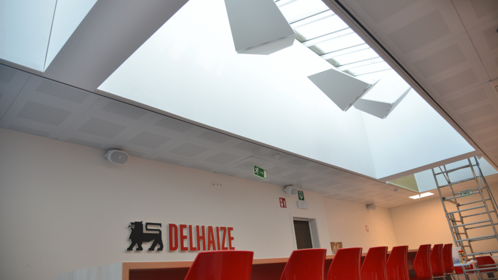 Akoestische wandbespanning in de lichtkoepels, akoestische wanden boven de bank en zwevende baffles in vlindervorm